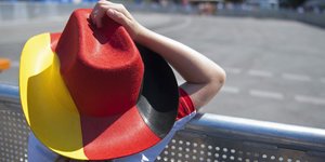Ein Mädchen mit einem Hut in den deutschen Nationalfarben vor einer Absperrung an der Fanmeile