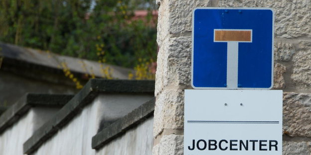 Ein Sackgassenschild über einem Schild, auf dem "Jobcenter" steht