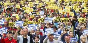 Gewerkschafter in Seoul halten gelbe Schilder in die Luft