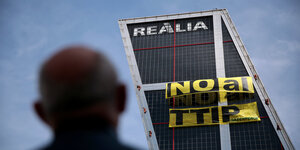 Kletterer der Umweltschutzorganisation Greenpeace lassen einen großen Banner gegen das TTIP-Freihandelsabkommen am Kio Tower in Madrid hinunter