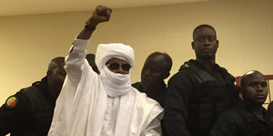 Exdiktator Hissène Habré hebt die Faust im Gerichtsaal