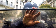 Ein Polizist hält seine Hand und sein Schild direkt in die Kamera