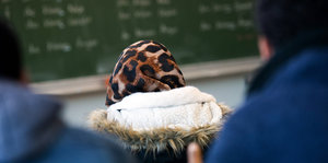 Eine Frau mit Kopftuch im Klassenzimmer