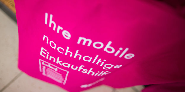 Auf einem pinkfarbenen Baumwollbeutel steht in weiß „Ihre mobile nachhaltige Einkaufshilfe“