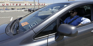 Ein Mann sitzt in einem Auto, vorn hinter der Windschutzscheibe ist das Uber-Logo zu sehen