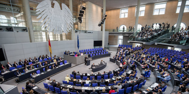 Blick in das Plenum des Bundestages. Im Hintergrund hängt der Bundesadler