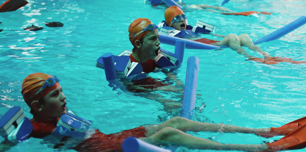 Kinder mit Badekappen und Tauscherbrillen im Schwimmbecken
