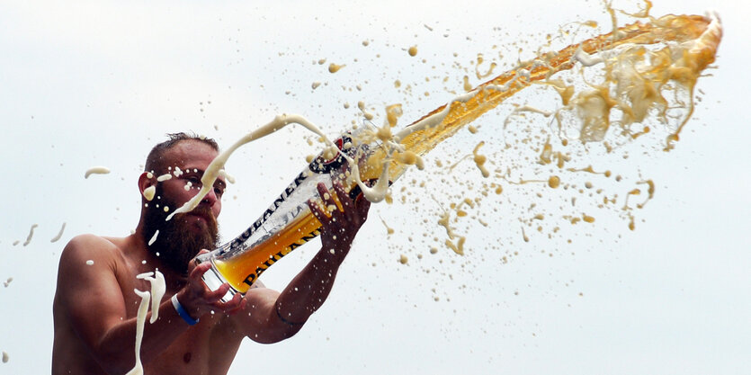 Ein Mann schüttet Weizenbier in die Luft