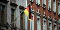 Eine Deutschlandfahne weht an einer Häuserwand