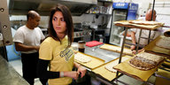 Virginia Raggi im gelben T-Shirt in der Küche einer Pizzeria