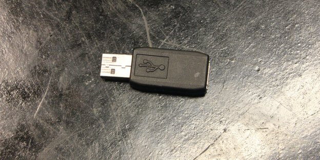 Ein Plastikteil mit USB-Anschluss liegt auf einer Fläche