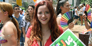Menschen tragen Regenbogen-Fächer bei LGBT-Parade in Tel Aviv
