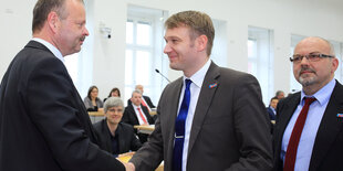 Daniel Rausch steht hinter André Poggenburg, als der Wulff Gallert die Hand schüttelt