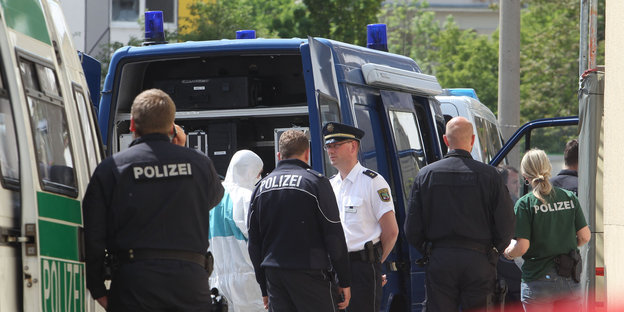 Polizisten stehen vor einem Auto Polizisten stehen vor einem Auto