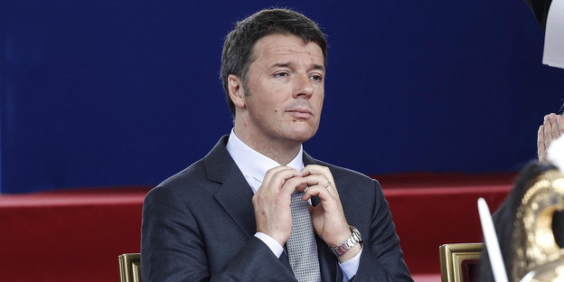 Matteo Renzi rückt im Sitzen seine Krawatte zurecht