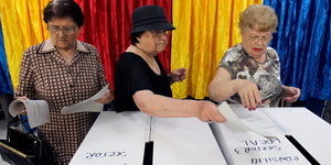 Frauen werfen ihren Stimmzettel in die Wahlurne.