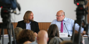Ein Mann mit langem blondem Haar, es ist Toni Hofreiter, und Peter Altmeier auf einer Pressekonferenz