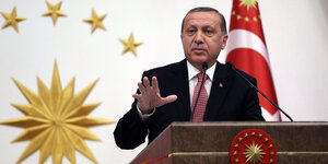 Der türkische Präsident Erdogan spricht hinter einerm Podium.
