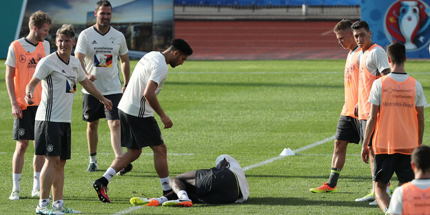 Nationalspieler versammeln sich um den verletzten Antonia Rüdiger, der sich auf dem Rasen vor Schmerzen krümmt.