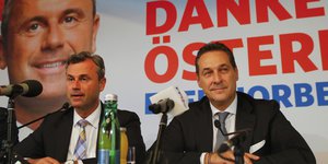 Die FPÖ-Politiker Norbert Hofer und Heinz-Christian Strache sitzen an einem Pult
