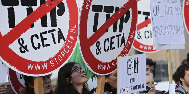 Demonstranten halten Schilder hoch, die sich gegen TTIP und Ceta aussprechen
