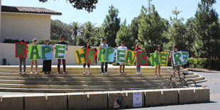 Student_innen halten Buchstaben hoch, die den Satz „Rape happens here“ ergeben