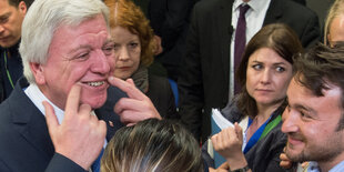 Der hessische Ministerpräsident Volker Bouffier zieht sich die Mundwinkel hoch