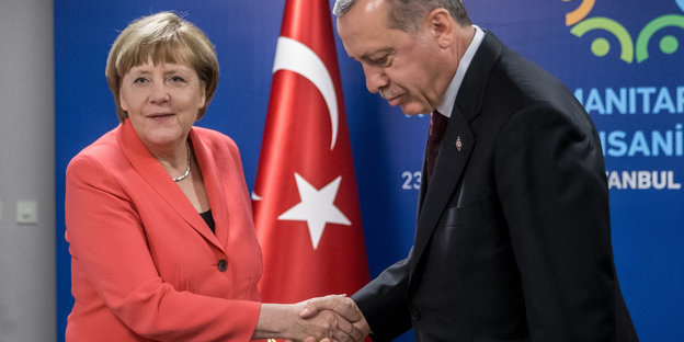 Angela Merkel schüttelt Recep Tayyip Erdoğan die Hand, er beugt den Kopf