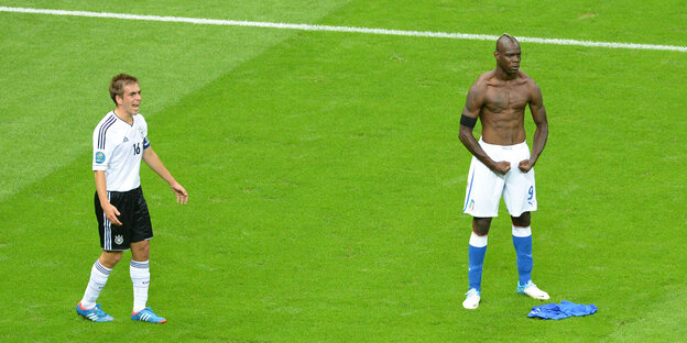 Philipp Lahm läuft über den Platz und beschwert sich. Daneben posiert Balotelli mit nacktem Oberkörper.