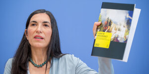 Die Amnesty-Generalsekretärin Selmin Caliskan hält einen Bericht hoch