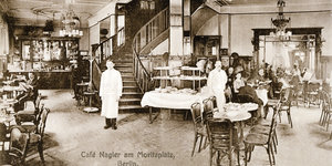 Eine historische Schwarzweiß-Postkarte mit der Innenansicht des "Café Nagler" in Berlin