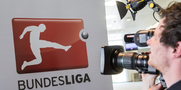 Ein Kameramann filmt das Bundesliga-Logo