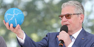 Bundespräsident Gauck mit Sonnenbrille hält im ausgestreckten linken arm eine kleine Weltkugel