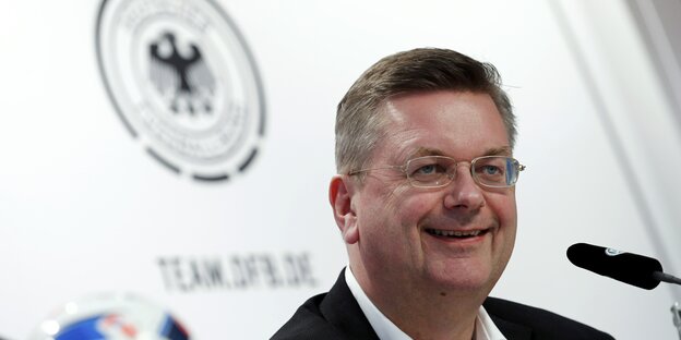 DfB-Präsident Reinhard Grindel lacht bei einer DFB-Pressekonferenz