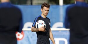 Antoine Griezmann hält auf dem Trainingsplatz einen Ball fest.