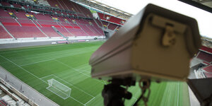 Eine Nahaufnahme einer Kamera die vom Stadiondach aus das Spielfeld filmt.