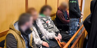 Vier junge Männer mit verpixelten Gesichtern sitzen auf einer Anklagebank, ein fünfter steht.