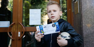 Ein Junge hält EM-Karten in der Hand
