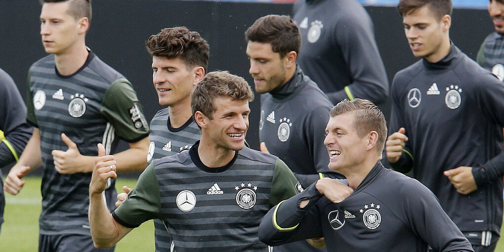 Die deutsche Nationalmannschaft trainiert. Thomas Müller scherzt beim Dauerlauf.