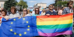 DemonstrantInnen hinter einer EU- und einer Regenbogenfahne