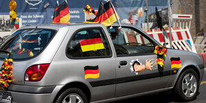 Ein Auto mit vielen Deutschland-Fahnen und -Aufklebern
