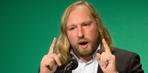 Mann mit langen blonden Haaren am Mikrophon, es ist der Grünen-Vorsitzende Toni Hofreiter
