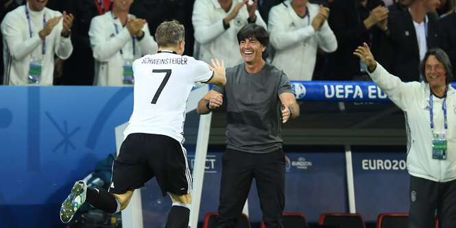 Jogi Löw reckt sein Kinn nach vorne, während Schweinsteiger auf ihn zustürmt