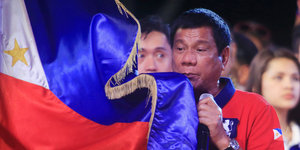 Mann mit Philippinen-Fahne, es ist Rodrigo Duterte