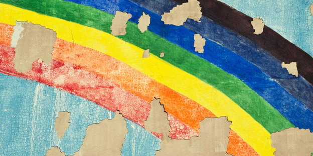 Ein auf eine Hauswand gemalter Regenbogen, der Verputz der Wand ist teilweise abgeblättert