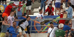 Russische Fans greifen englische Fans auf einer Tribüne an.