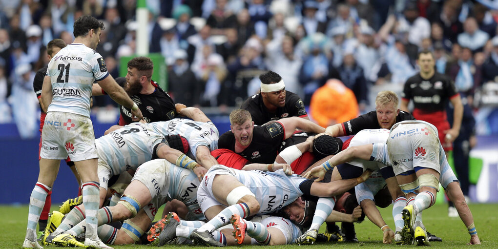 Etwa 12 Rugby-Spieler stürzen sich auf das Rugby-Ei, das irgendwo unter ihnen begraben ist