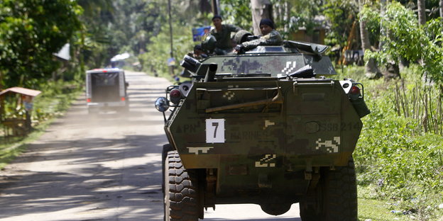 Ein philippinischer Panzerwagen patrouilliert auf einer Straße durch den Wald.