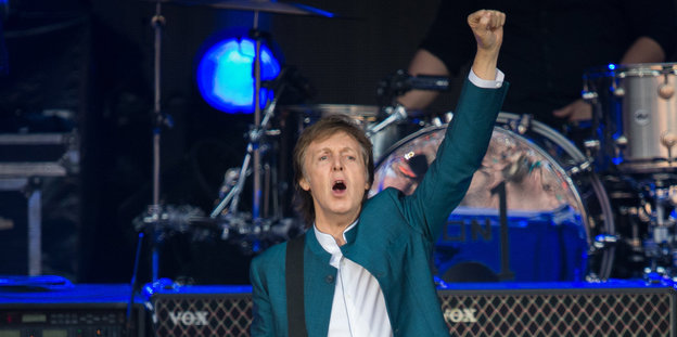 Paul McCartney auf der Bühne. Er reckt die Faust.