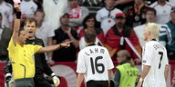 Ein Schiedsrichter zeigt dem Fußballer Bastian Schweinsteiger die rote Karte, auch Philipp Lahm ist im Bild